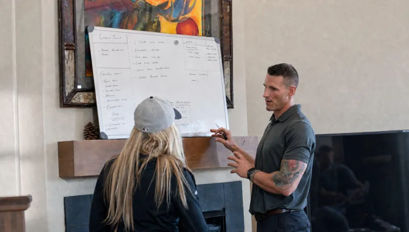 Josh Rowe working through a plan on a whiteboard with a client